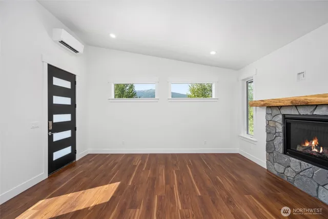 a view of wooden floor fire place and windows in a room