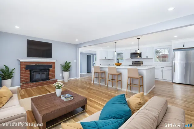 a living room with furniture fireplace and kitchen view