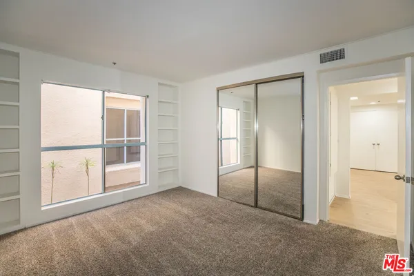 an empty room with windows and wooden floor