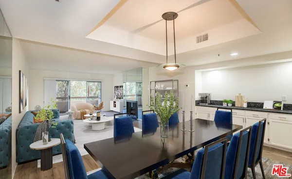 a view of a dining room and livingroom with furniture wooden floor a chandelier