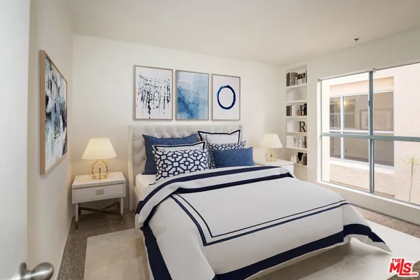 a bedroom with a bed and a large window