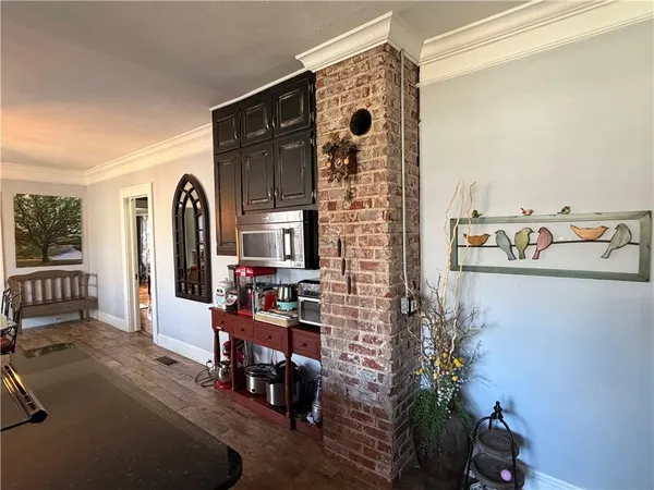 a view of a hallway with wooden floor and a livingroom with furniture