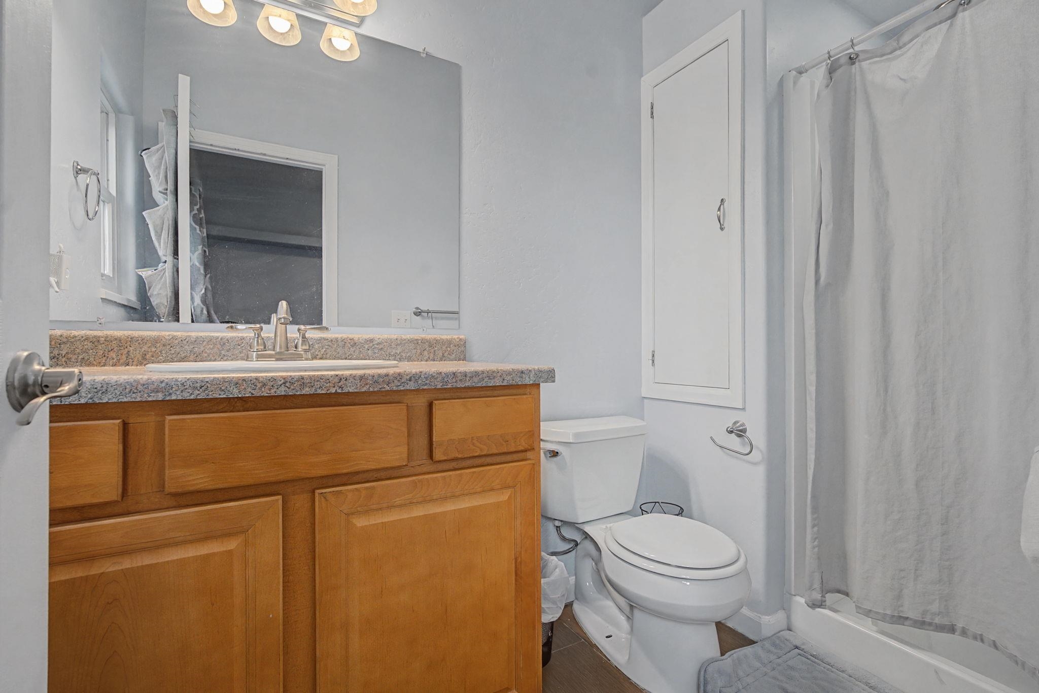 3055 E Road Grand Junction, CO 81504 - Photo 12 of 32 a bathroom with a granite countertop sink toilet and mirror