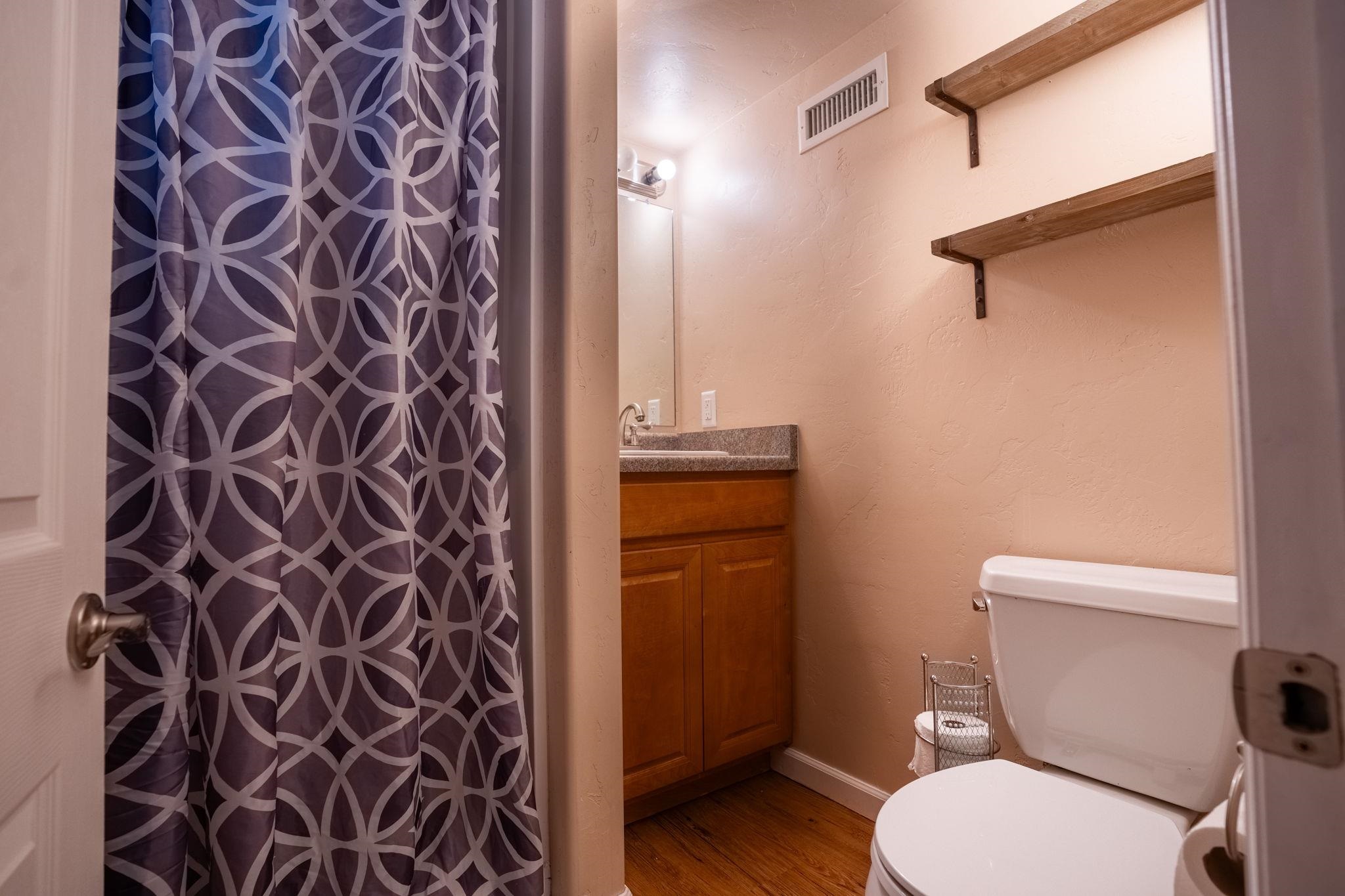 3055 E Road Grand Junction, CO 81504 - Photo 21 of 32 a white toilet sitting next to a shower curtain