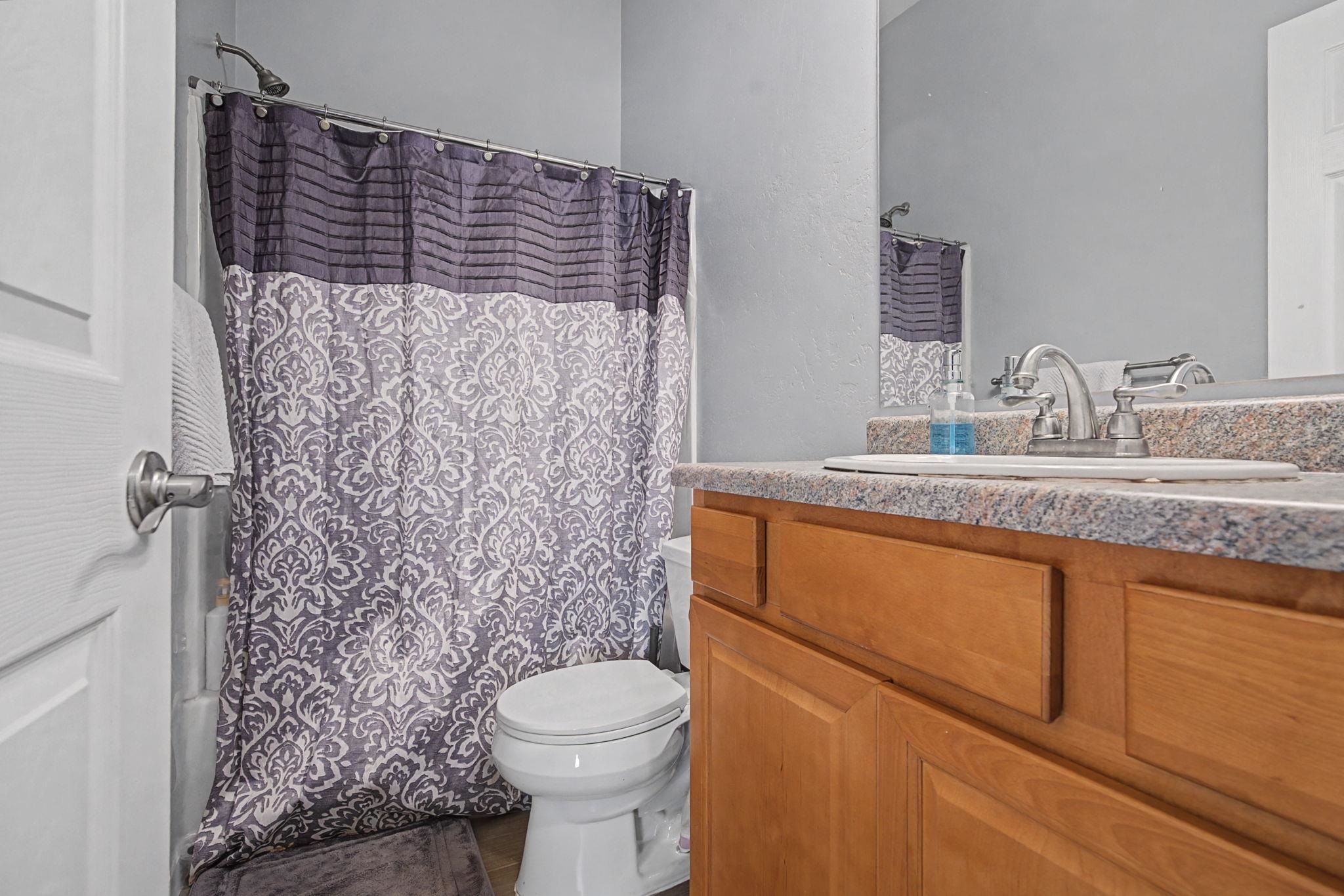 3055 E Road Grand Junction, CO 81504 - Photo 10 of 32 a bathroom with a granite countertop sink toilet and shower