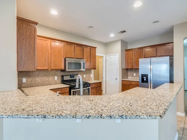 a kitchen with stainless steel appliances granite countertop a stove sink and cabinets