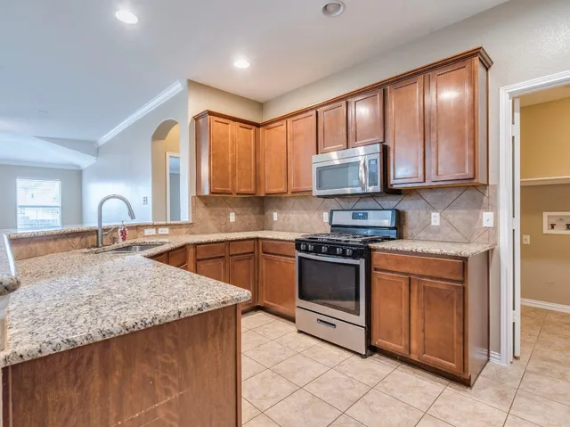 a kitchen with stainless steel appliances granite countertop a sink and a stove