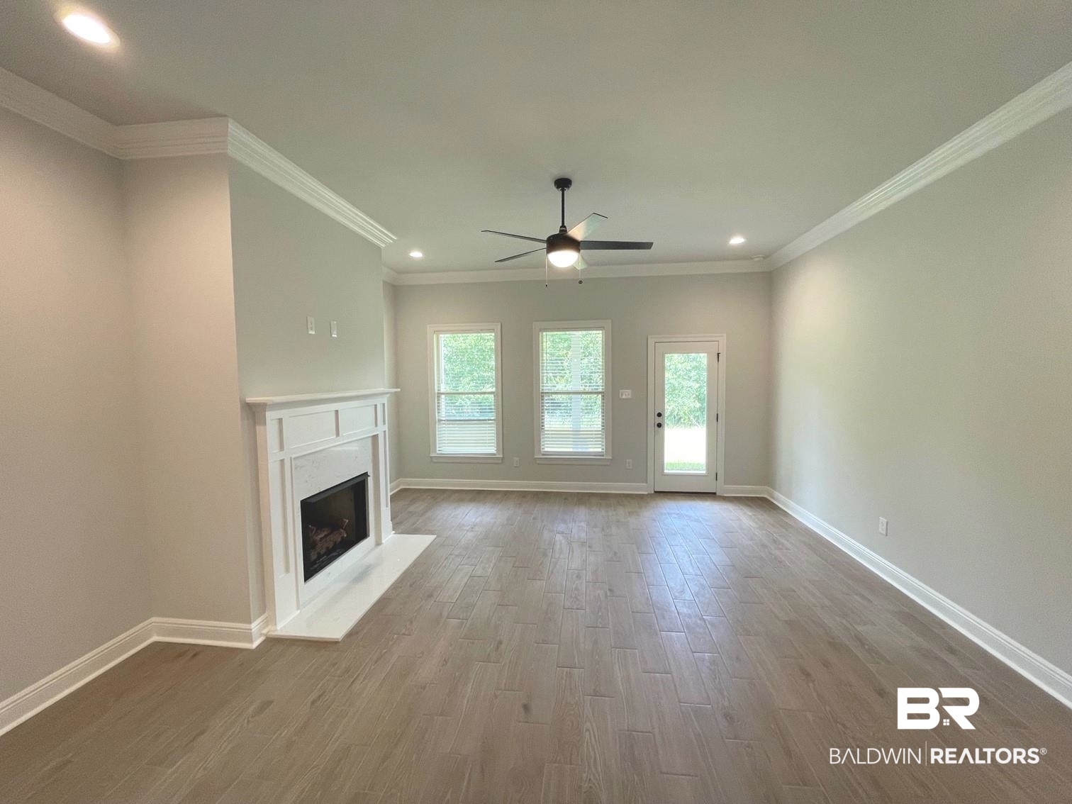 1626 Fenton Circle Foley, AL 36535 - Photo 4 of 16 Unfurnished living room featuring wood-type flooring, ceiling fan, and crown molding