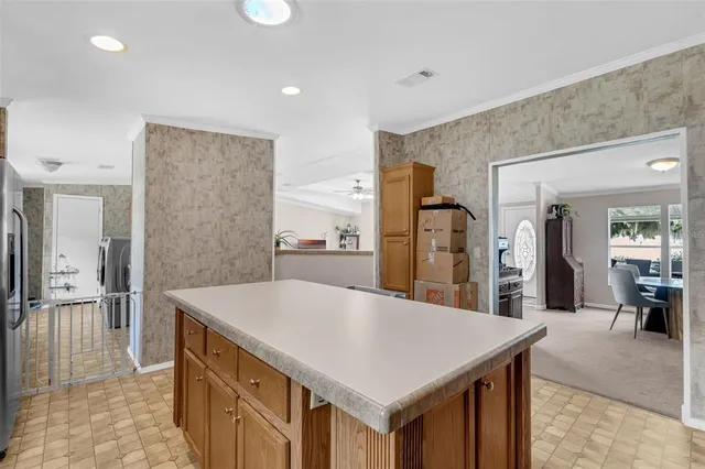 a kitchen with stainless steel appliances kitchen island a table and chairs