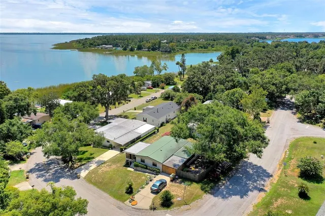 an aerial view of a houses with outdoor space and lake view