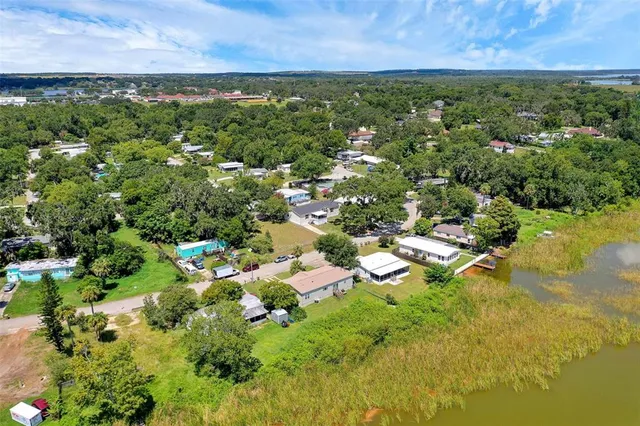 an aerial view of residential houses with outdoor space and trees all around
