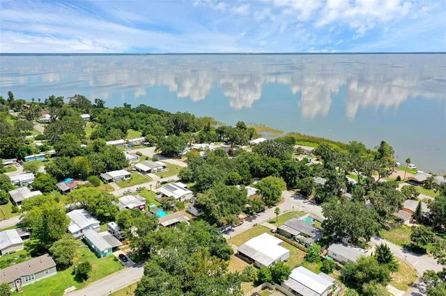 an aerial view of residential houses with outdoor space and trees all around