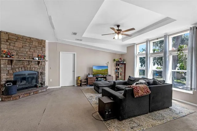 a living room with furniture a fireplace and a floor to ceiling window