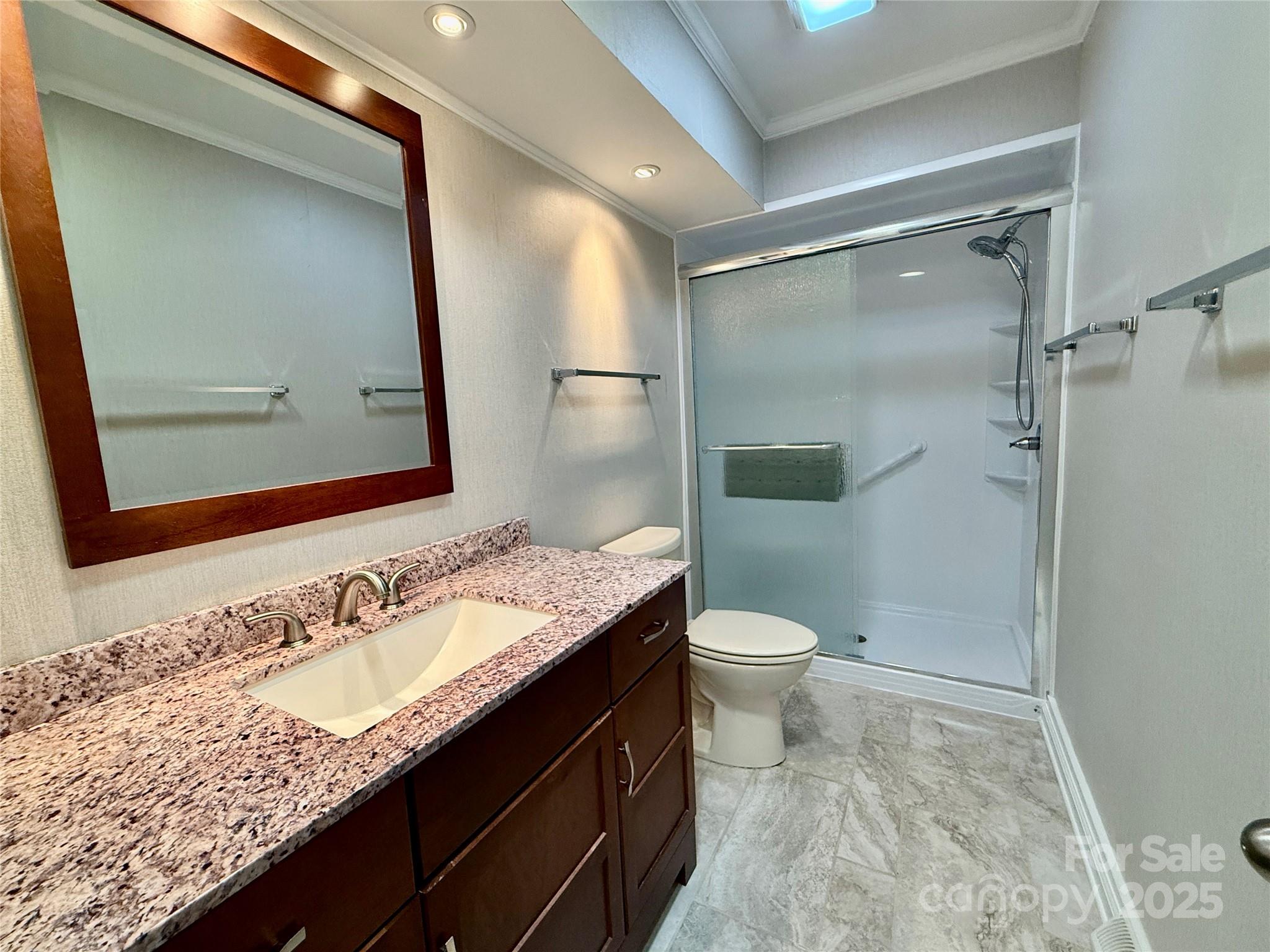 77 Chestnut Street, Unit 103 Tryon, NC 28782 - Photo 11 of 17 a bathroom with a granite countertop sink toilet and shower
