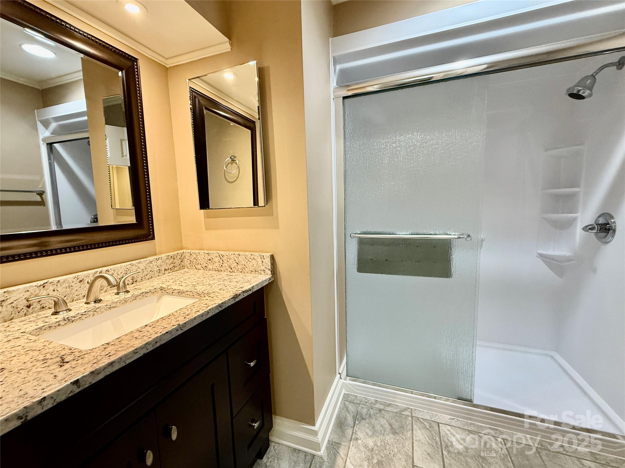 77 Chestnut Street, Unit 103 Tryon, NC 28782 - Photo 17 of 17 a bathroom with a granite countertop sink and mirror