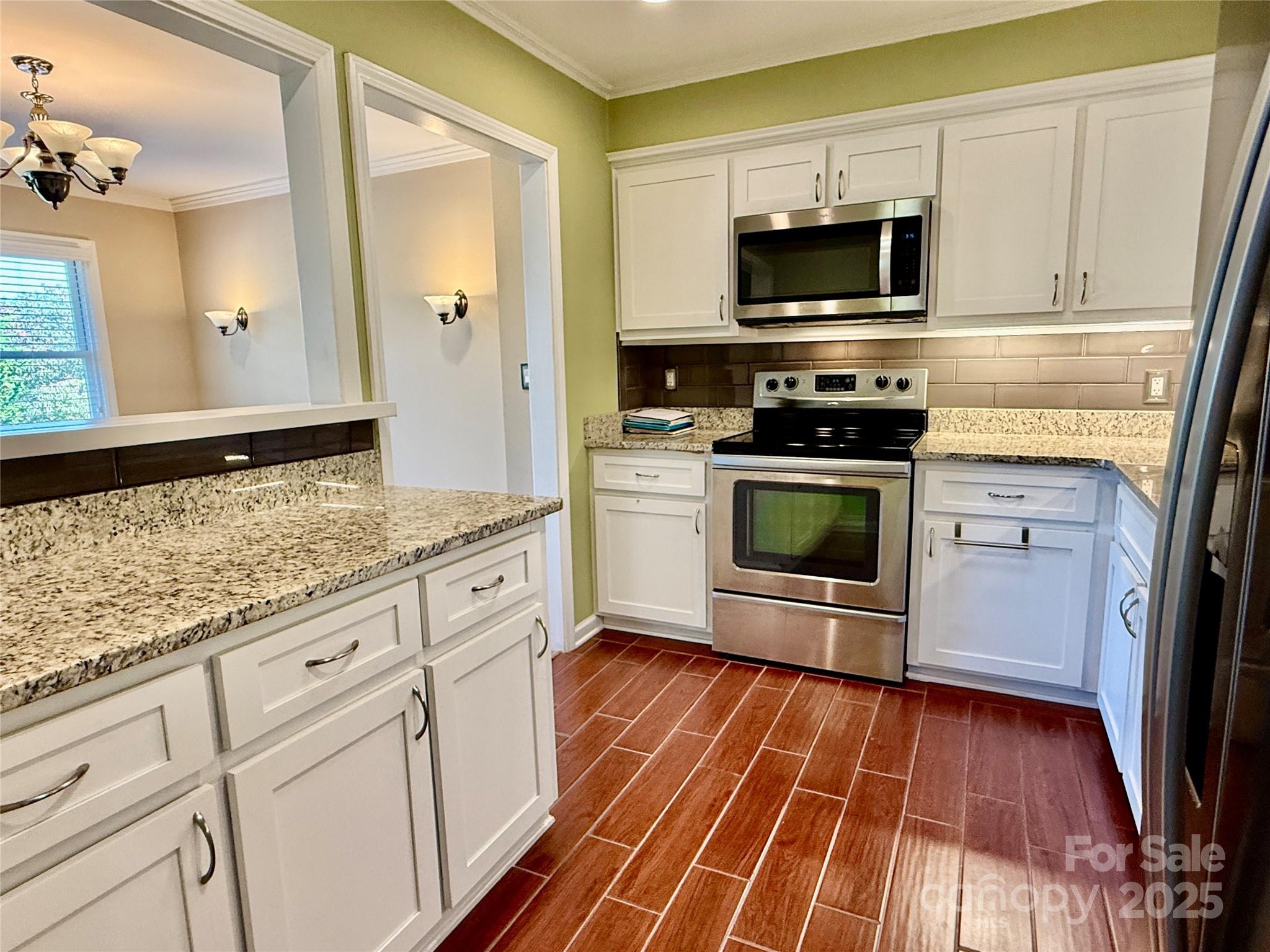 77 Chestnut Street, Unit 103 Tryon, NC 28782 - Photo 9 of 17 a kitchen with granite countertop a sink cabinets and stainless steel appliances