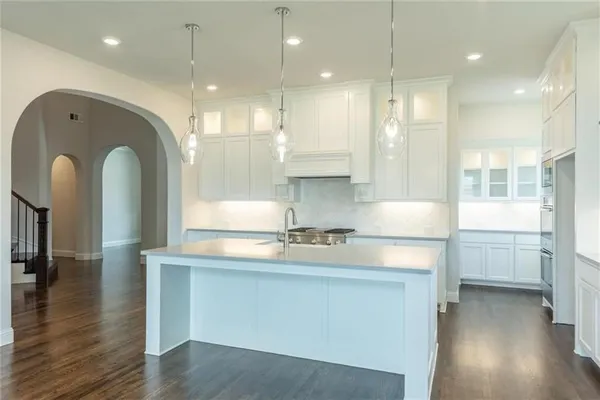 a kitchen with kitchen island a sink appliances and cabinets