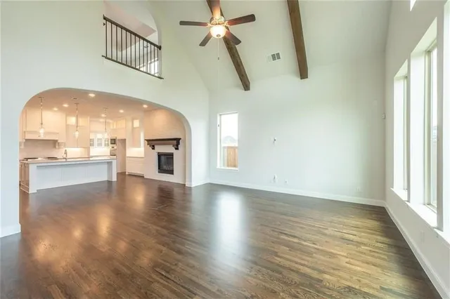 a view of a livingroom with wooden floor and a kitchen space