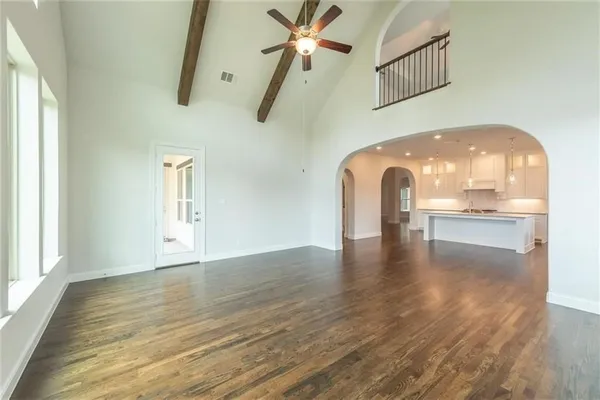 a view of a livingroom with wooden floor and a ceiling fan