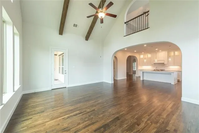 a view of a livingroom with wooden floor and a ceiling fan