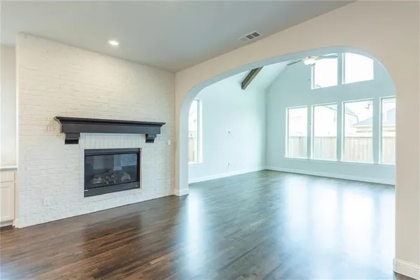 an empty room with wooden floor and a fireplace