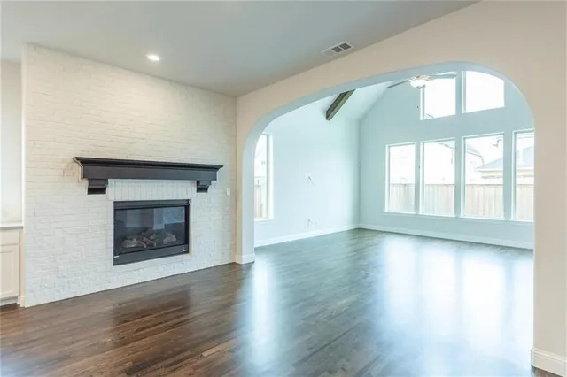 an empty room with wooden floor and a fireplace