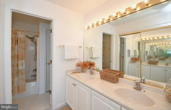 a bathroom with double vanity sinks and a mirror