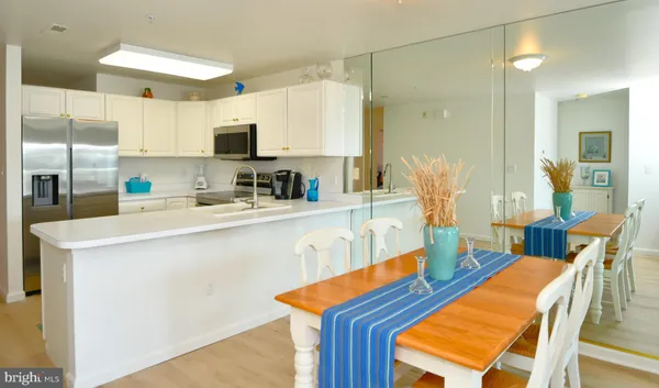 a kitchen with stainless steel appliances kitchen island granite countertop a sink a stove and a refrigerator