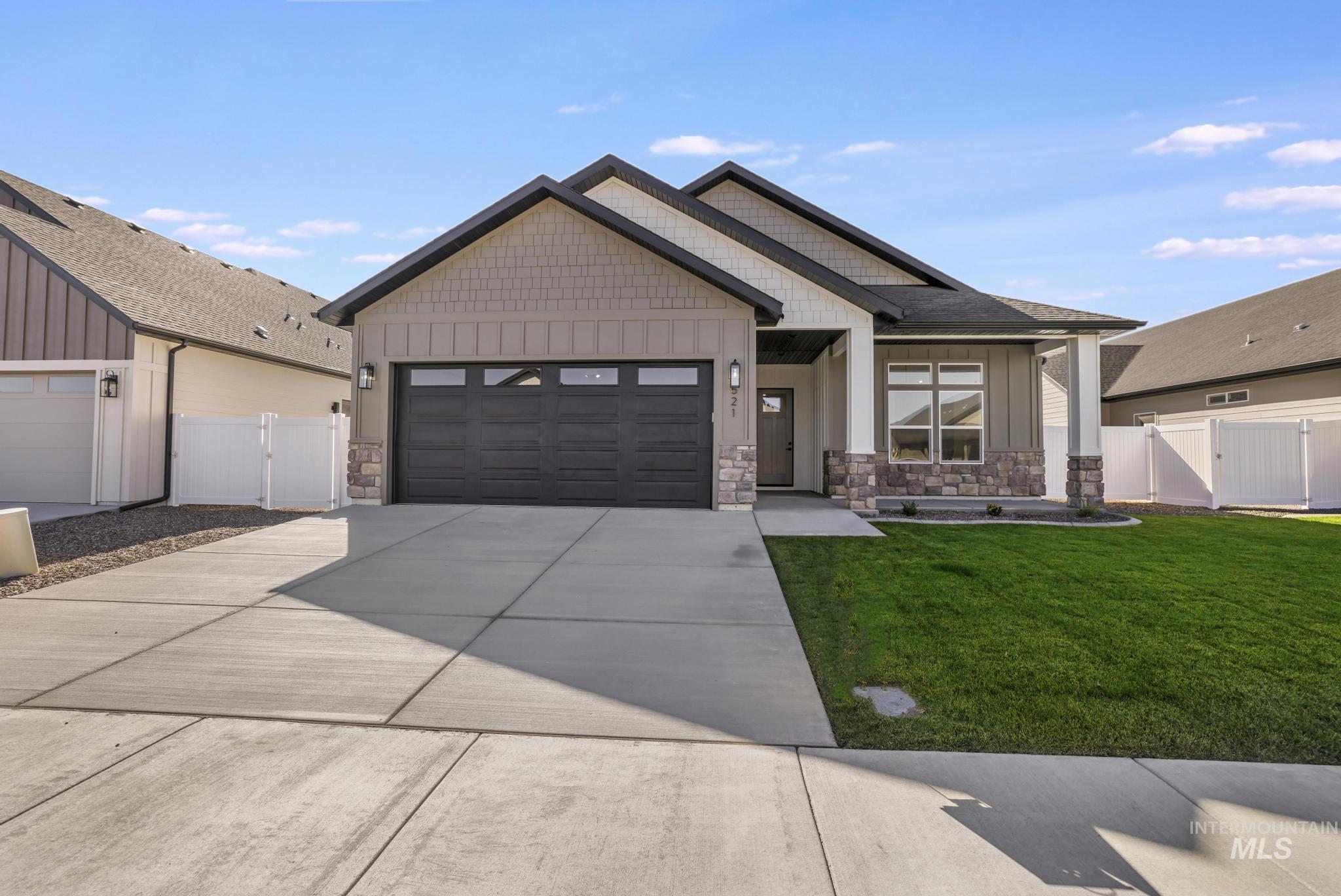 521 Falling Leaf Lane Twin Falls, ID 83301 - Photo 2 of 42 Craftsman house with board and batten siding, stone siding, a gate, concrete driveway, and an attached garage