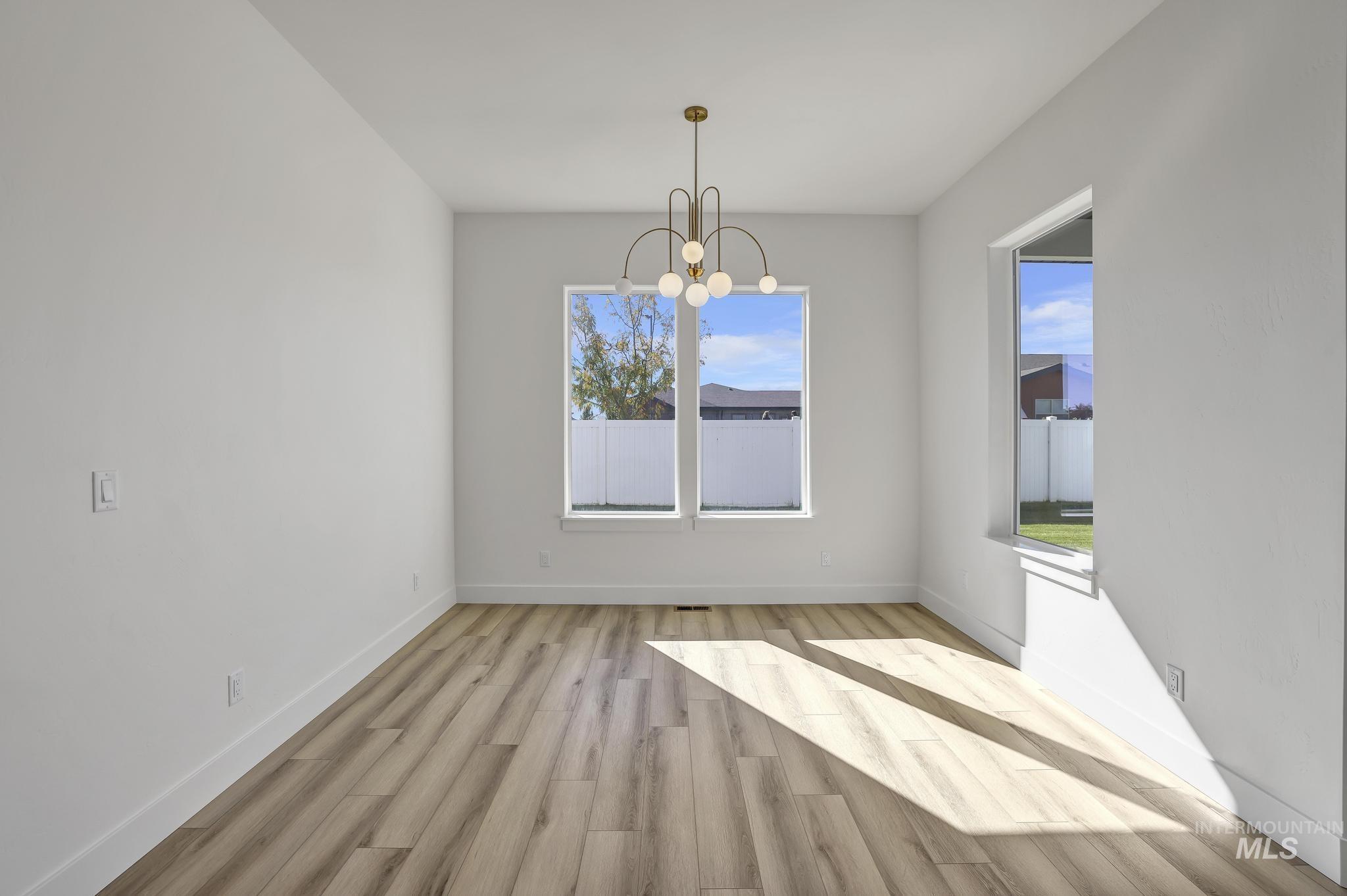 521 Falling Leaf Lane Twin Falls, ID 83301 - Photo 25 of 42 Unfurnished dining area with light wood-type flooring and a chandelier