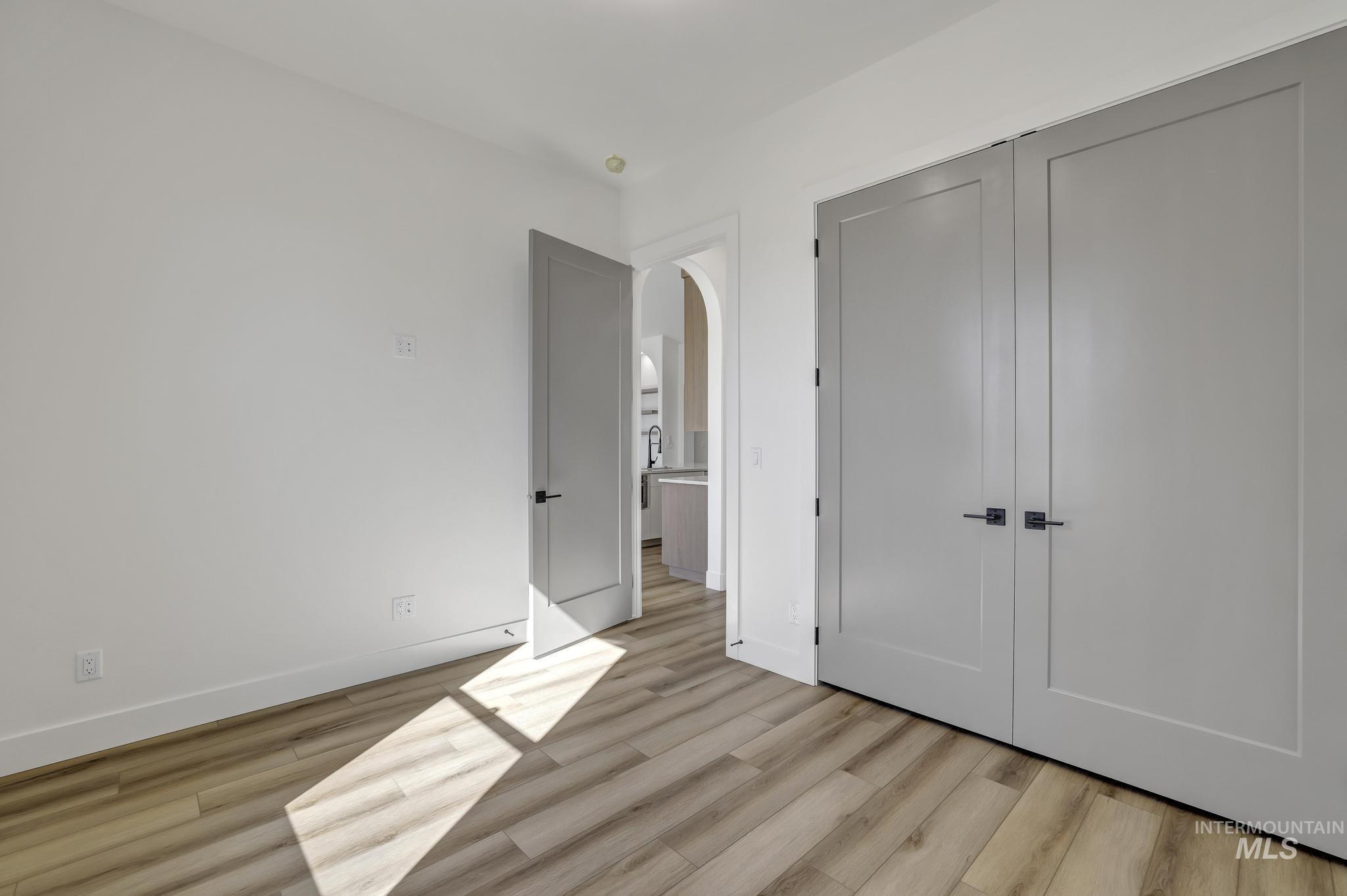 521 Falling Leaf Lane Twin Falls, ID 83301 - Photo 27 of 42 Unfurnished bedroom featuring a closet, light wood-style floors, and arched walkways