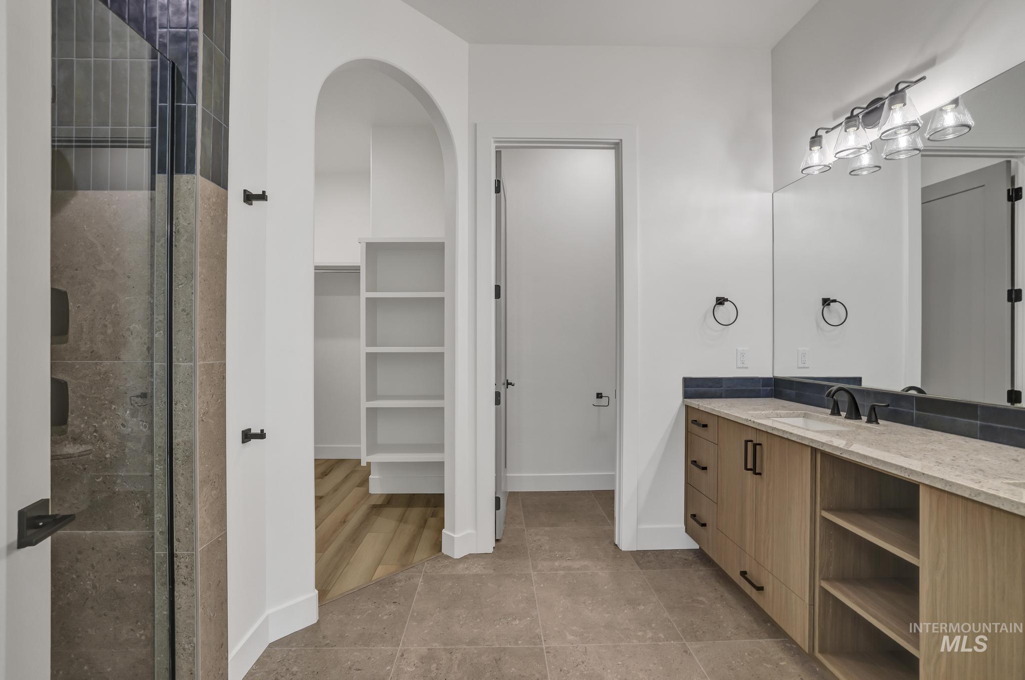 521 Falling Leaf Lane Twin Falls, ID 83301 - Photo 30 of 42 Full bathroom with vanity, a spacious closet, light tile patterned floors, and tiled shower