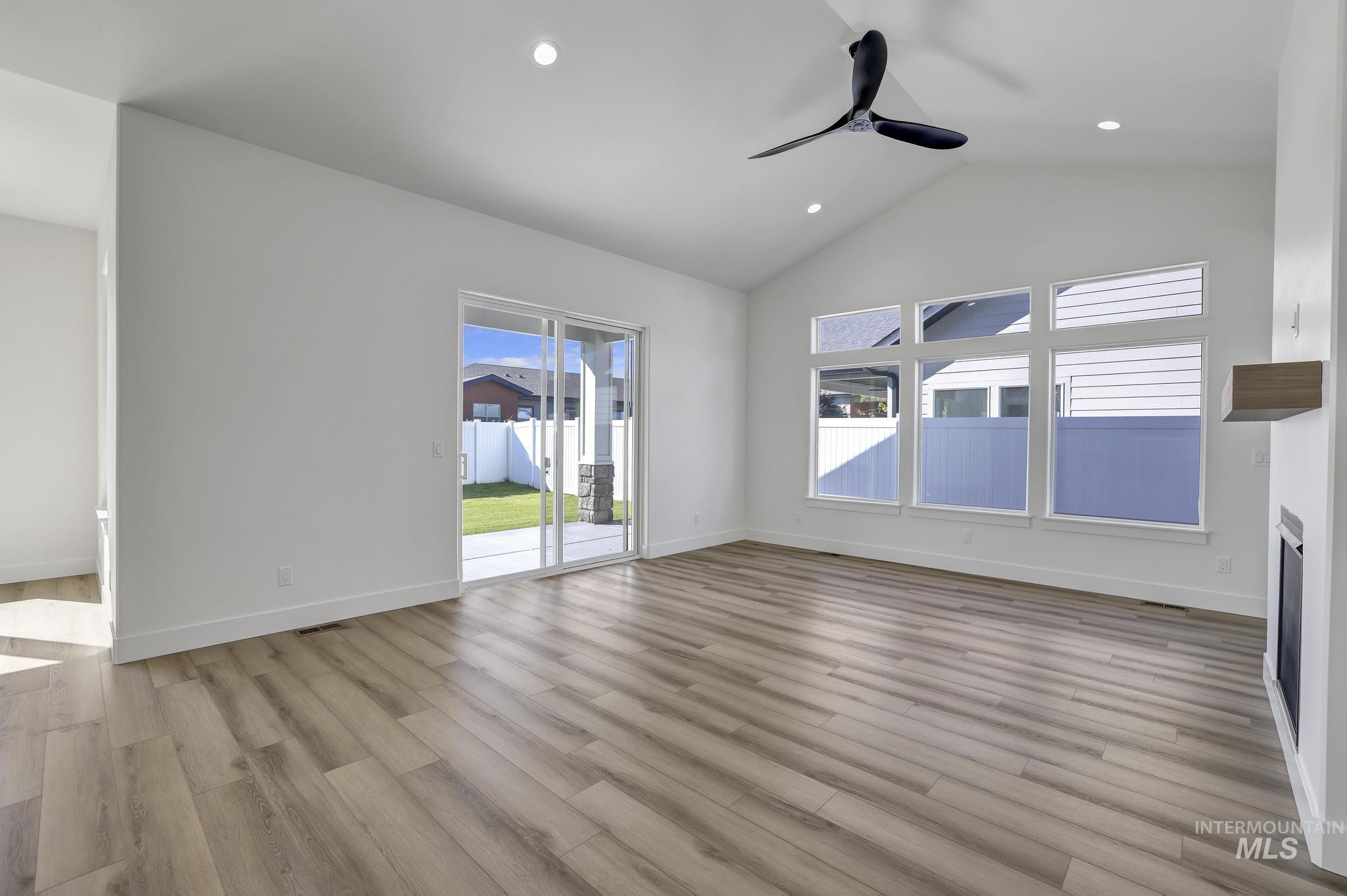 521 Falling Leaf Lane Twin Falls, ID 83301 - Photo 10 of 42 Unfurnished living room featuring light wood-style floors, recessed lighting, a ceiling fan, high vaulted ceiling, and a fireplace