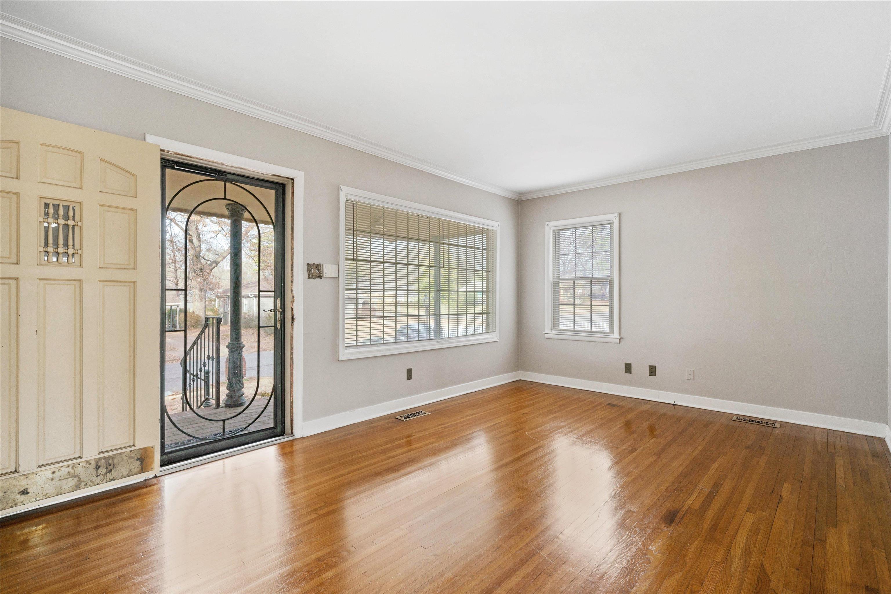 4863 Amboy Road Memphis, TN 38117 - Photo 7 of 26 a view of an empty room with wooden floor and a window