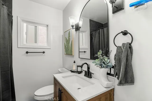 a bathroom with a sink a toilet and mirror