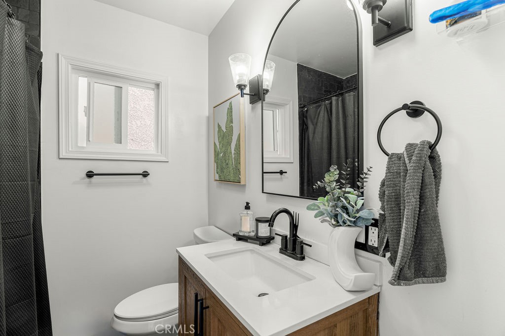 2015 Wayside Street Compton, CA 90222 - Photo 15 of 27 a bathroom with a sink a toilet and mirror