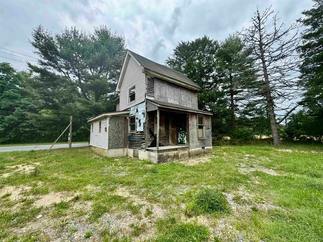 a view of a house with backyard and trees
