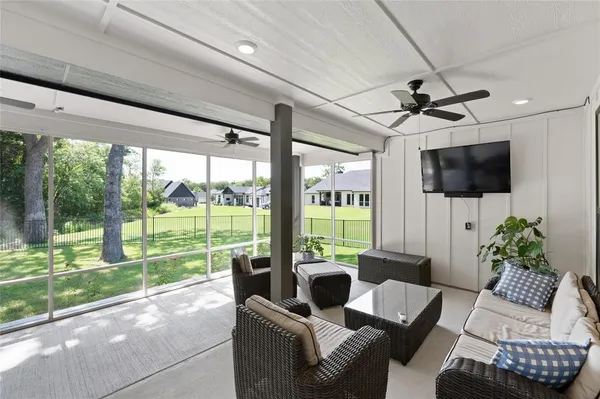 a living room with patio furniture and a flat screen tv