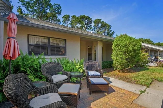 a view of a chair and table in the back yard of the house