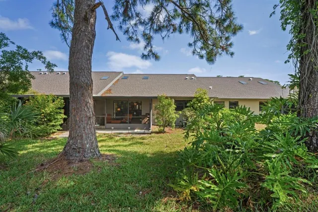 an aerial view of residential house with outdoor space and trees all around