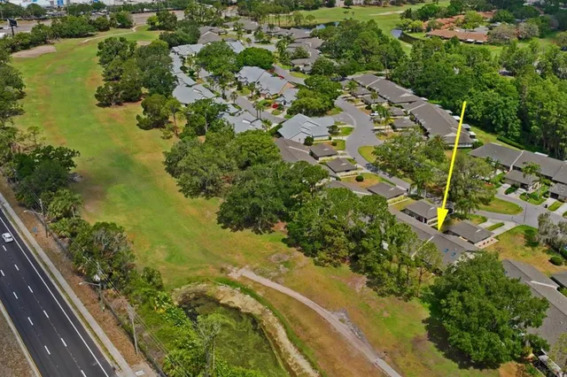 an aerial view of residential house with outdoor space and trees all around