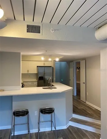a kitchen with a sink cabinets and wooden floor