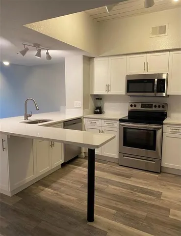 a kitchen with a sink and a stove top oven