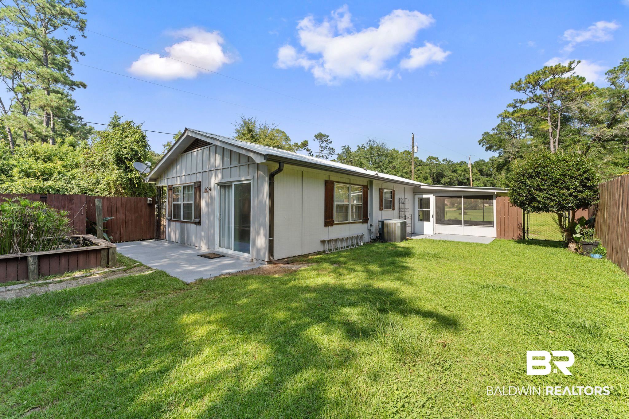 14095 Riverside Drive Foley, AL 36535 - Photo 24 of 30 Back of property with a fenced backyard and a patio