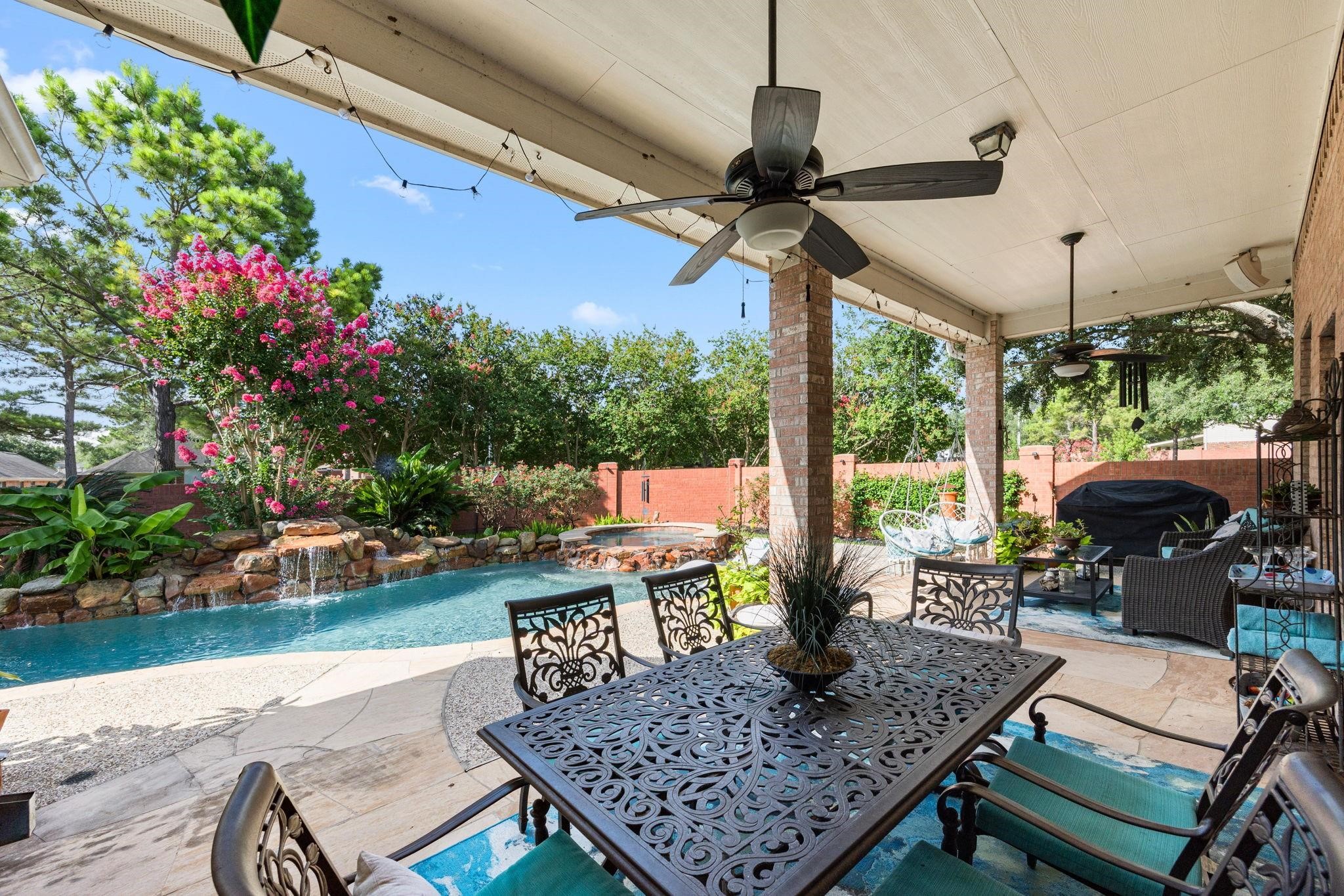 4402 Eden Point Lane Katy, TX 77494 - Photo 35 of 39 WELCOME TO YOUR PRIVATE RETREAT *THIS INVITING SALT WATER HEATED POOL/SPA WITH 7 ROCK WATERFALLS, FLAGSTONE PATIO & DECKING SURROUNDED BY LUSH FLOWERING LANDSCAPING WITH SURROUND SOUND AND HOA BRICK PRIVACY FENCE IS A MUST SEE.
BARBEQUE PIT AND AQUA DOUBLE COVERED LOUNGER (stays with home).