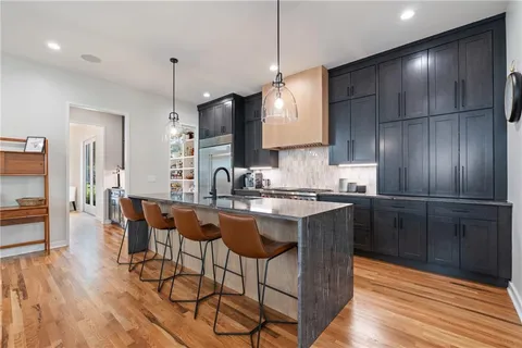 a kitchen with stainless steel appliances granite countertop a stove a sink and a refrigerator