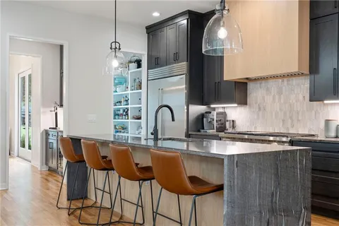 a very nice looking dining room with kitchen island furniture a large window and kitchen view