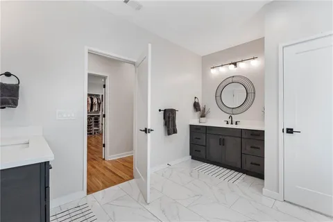 a bedroom with a bed chandelier and a mirror
