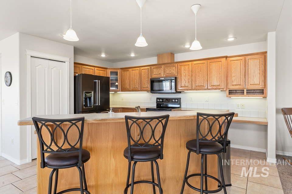 2924 27th Street Clarkston, WA 99403 - Photo 11 of 36 Kitchen featuring black appliances, light tile patterned floors, light countertops, pendant lighting, and recessed lighting