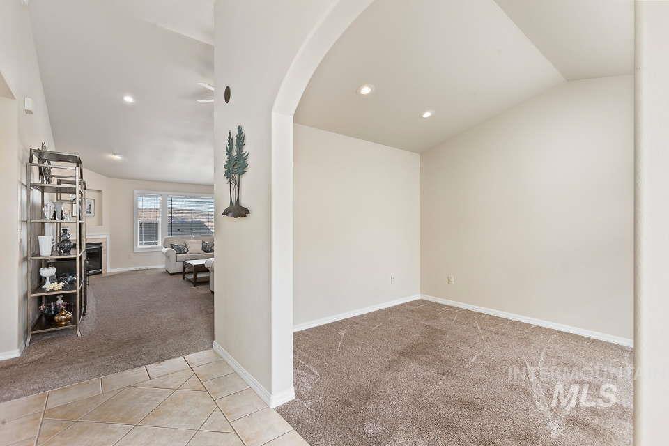 2924 27th Street Clarkston, WA 99403 - Photo 14 of 36 Tiled empty room with carpet, lofted ceiling, arched walkways, a fireplace, and recessed lighting
